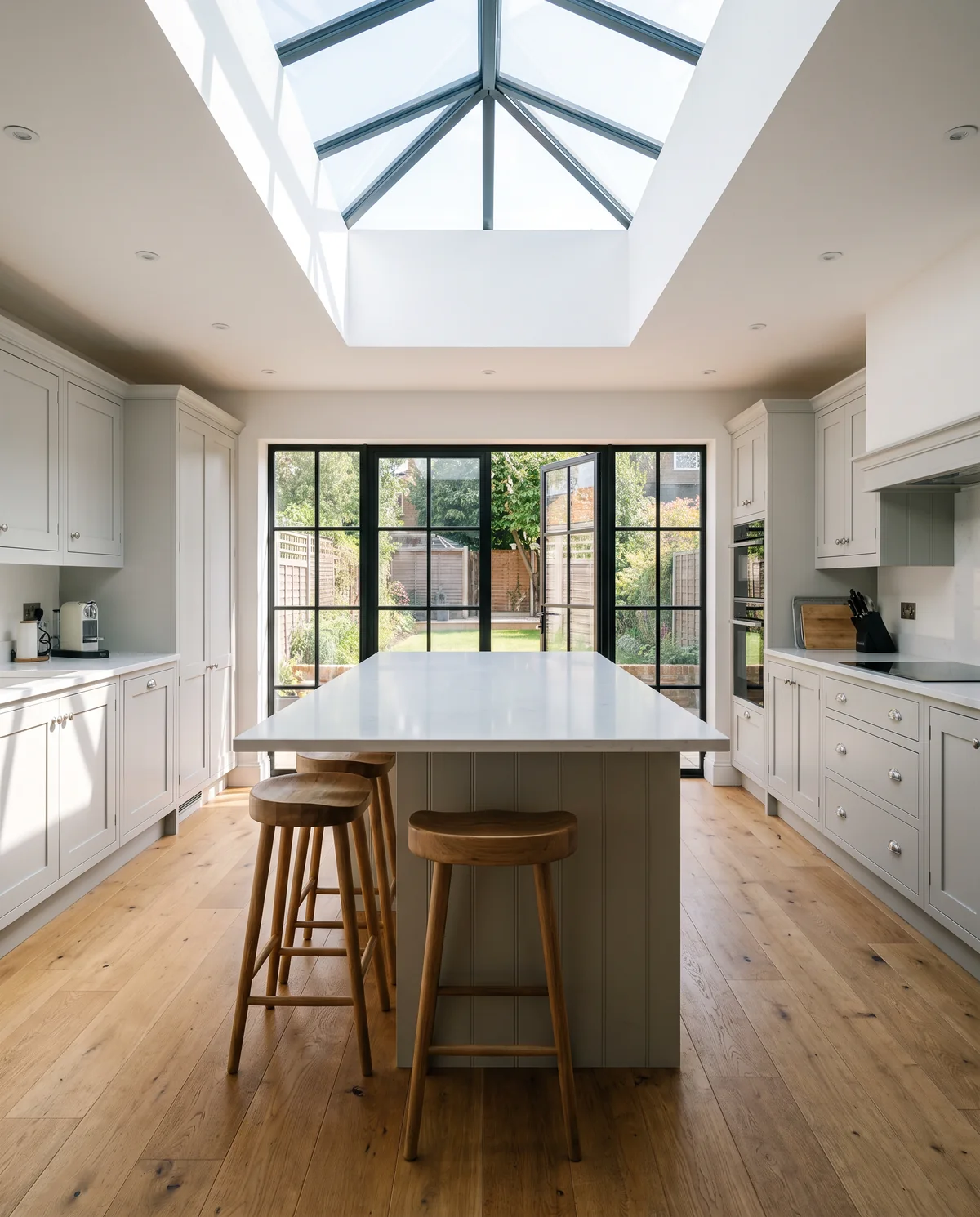 A new kitchen extension with a large island under a glass roof lantern