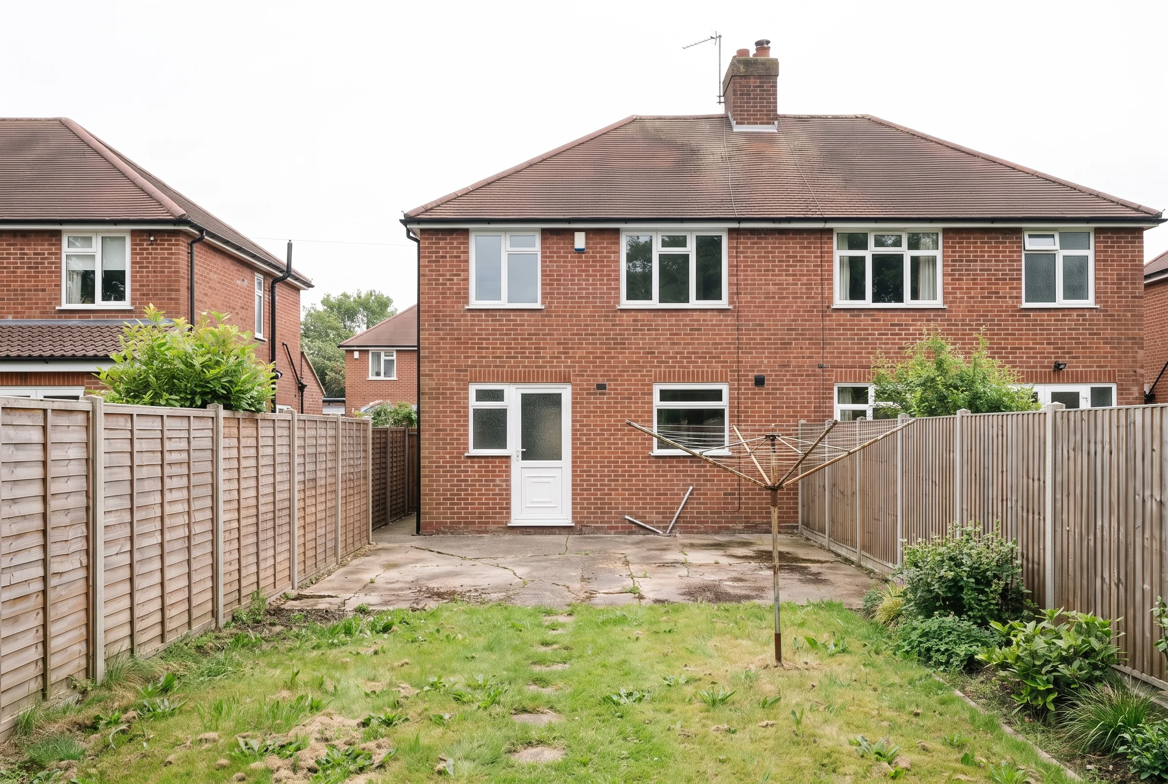 Before: the back of the house with an old patio, a washing line and a worn lawn